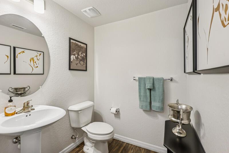 A powder room features a pedestal sink, a toilet, and framed artwork on the walls — WEST PALM BEACH, FL