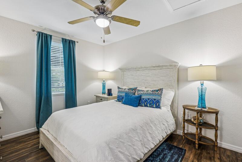 A bedroom features a white bed, blue curtains, and two matching blue glass lamps — WEST PALM BEACH, FL