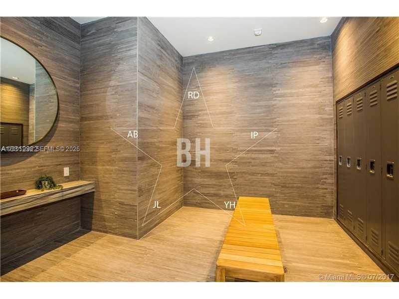 A locker room features wood-paneled walls, a wooden bench, and a circular wall mirror — 55 SW 9th St # 3610, Miami FL 33130, MIAMI, FL