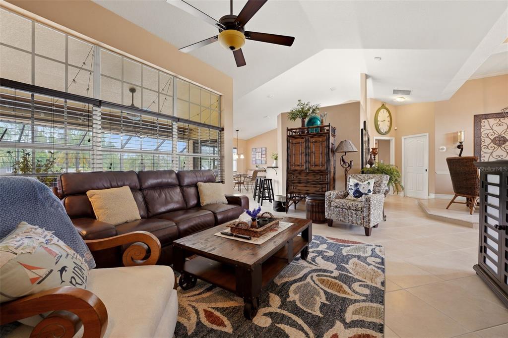 A living room features a leather sofa, patterned rug, and a ceiling fan — 3420 S SUMTER BOULEVARD, NORTH PORT, FL