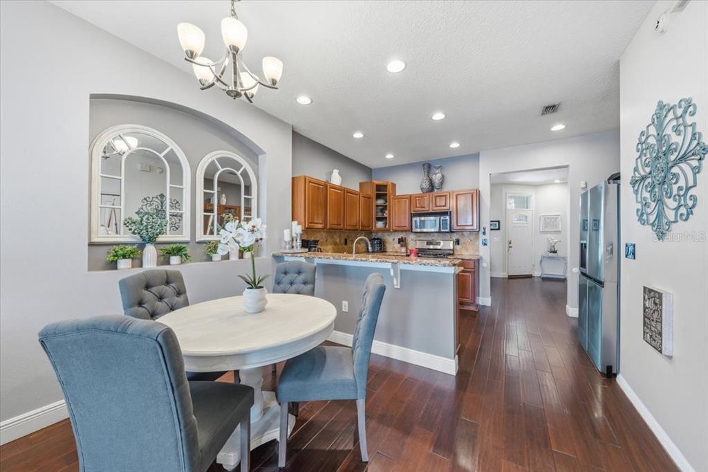 A dining area with a round table and chairs sits adjacent to a kitchen — 9606 ROYCE DRIVE, TAMPA, FL