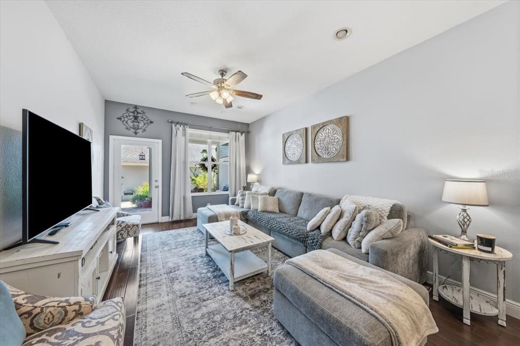 A living room features a grey sectional sofa, a white coffee table, and a television — 9606 ROYCE DRIVE, TAMPA, FL