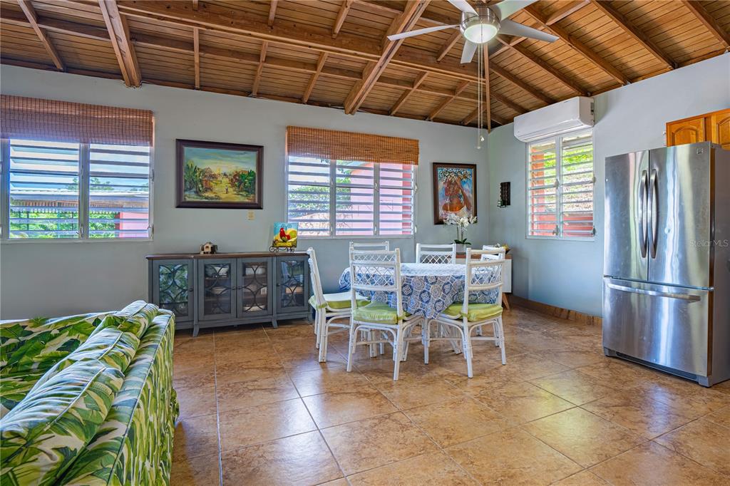 A dining area with a wooden vaulted ceiling, tile floors, and a stainless steel refrigerator — 2 #8 URBANIZABLE. VILLA SOÑDA, TRUJILLO ALTO, PR