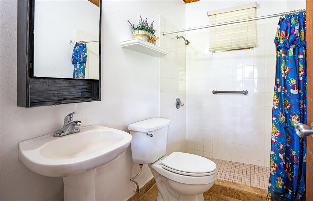 A bathroom features a pedestal sink, a toilet, and a walk-in shower with tiled walls — 2 #8 URBANIZABLE. VILLA SOÑDA, TRUJILLO ALTO, PR