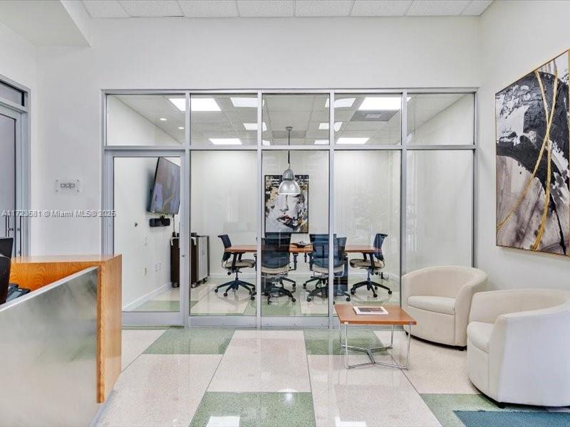 A glass-walled conference room sits behind a reception area with two white armchairs — 2404 Hollywood Blvd, Hollywood FL 33020, HOLLYWOOD, FL