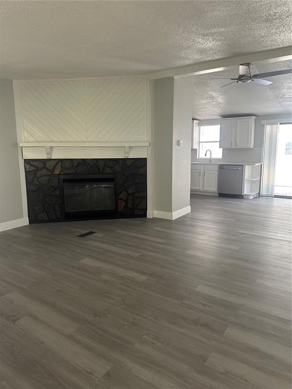A living room with a stone fireplace and chevron wood paneling opens into a kitchen — 18021 APPLEJACK COURT, SPRING HILL, FL