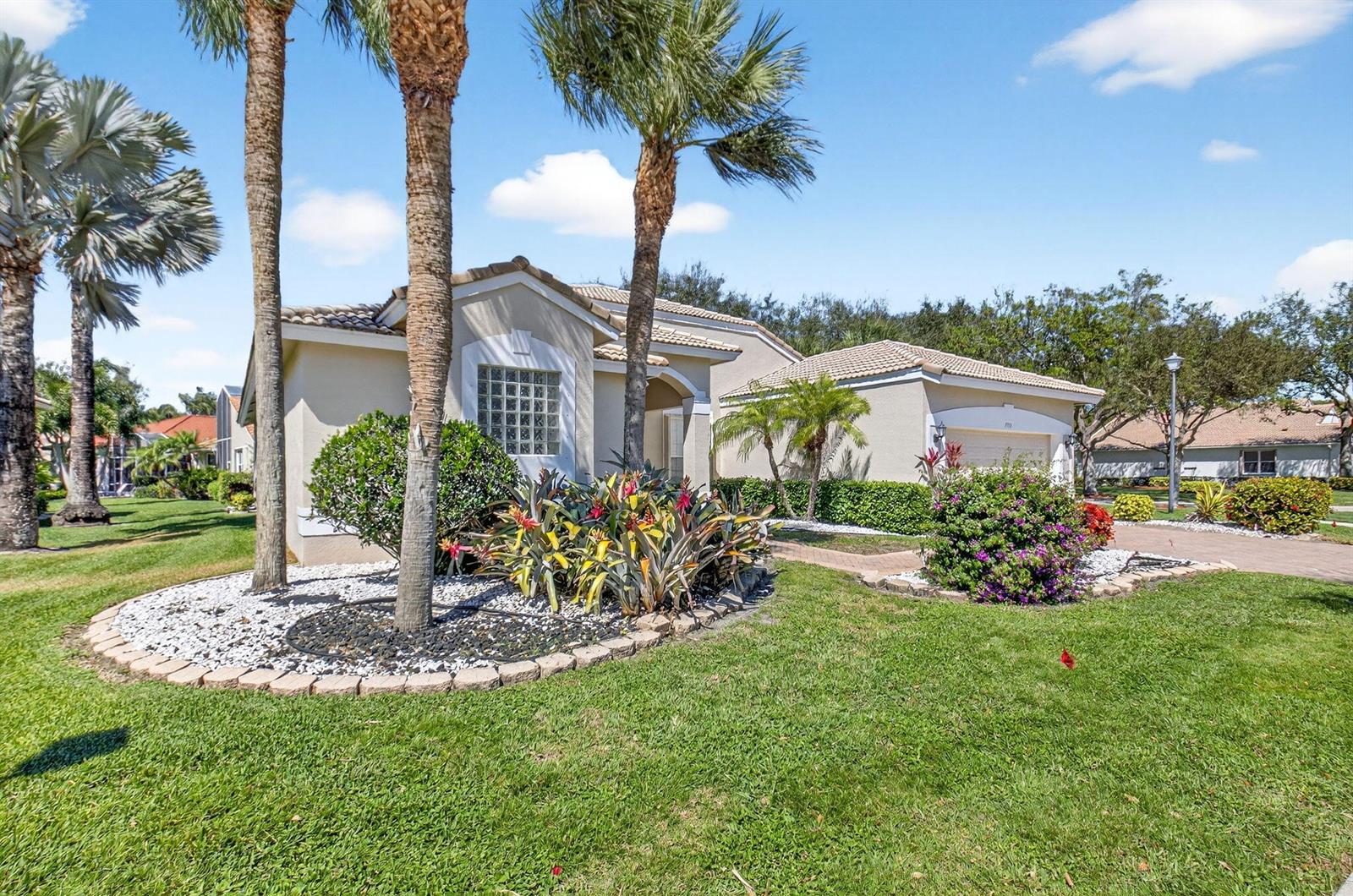 A single-story house with a tile roof, palm trees, and landscaped yard under a blue sky — 7713 Rinehart Drive, Boynton Beach FL 33437, BOYNTON BEACH, FL