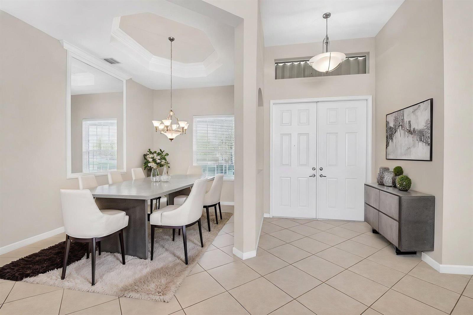 A dining area with a tray ceiling and a foyer with double doors and tile — 7713 Rinehart Drive, Boynton Beach FL 33437, BOYNTON BEACH, FL