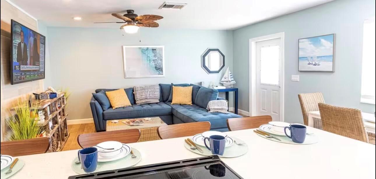 A living room with a blue sectional sofa, a television, and a kitchen island foreground — 85 S Las Olas Drive, Jensen Beach FL 34957, JENSEN BEACH, FL