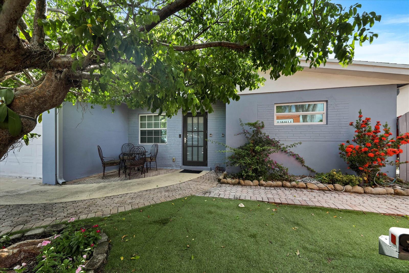 A gray brick house features a front patio, a large tree, and a paved walkway — 3850 NE 12th Terrace, Pompano Beach FL 33064, POMPANO BEACH, FL
