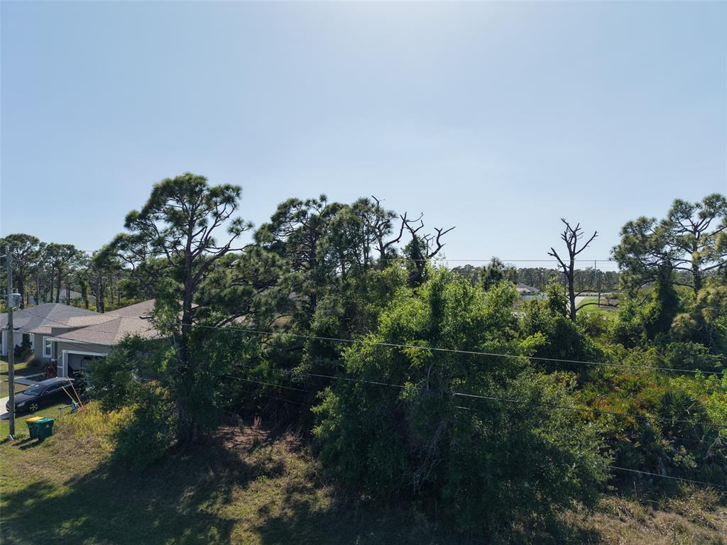 An aerial view shows a residential lot with mature trees and a nearby house — 274 SWEETWATER DRIVE, ROTONDA WEST, FL