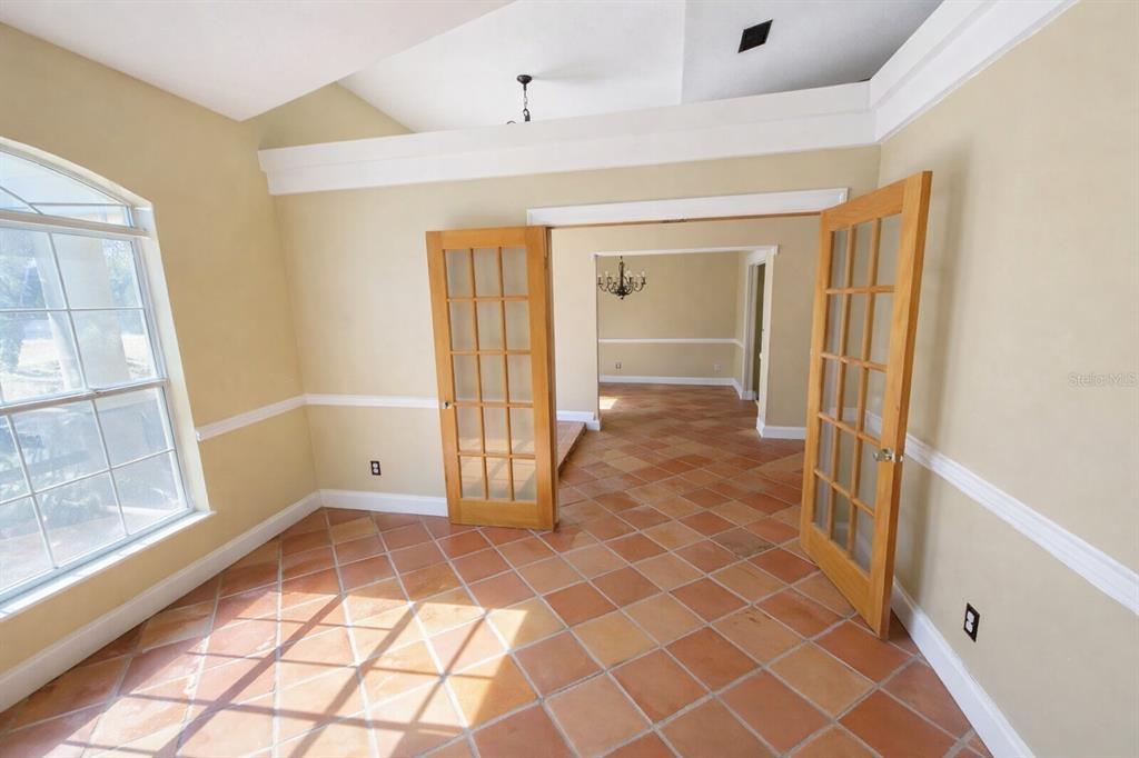 A room with terracotta tile flooring, light-colored walls, and French doors leading to another space — 791 SE 142 AVENUE, WILLISTON, FL