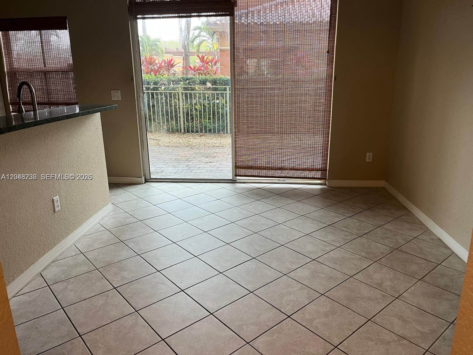 A tiled dining area features a sliding glass door leading to a fenced patio — 4952 Tradewinds Ter # 506, Dania Beach FL 33312, DANIA BEACH, FL