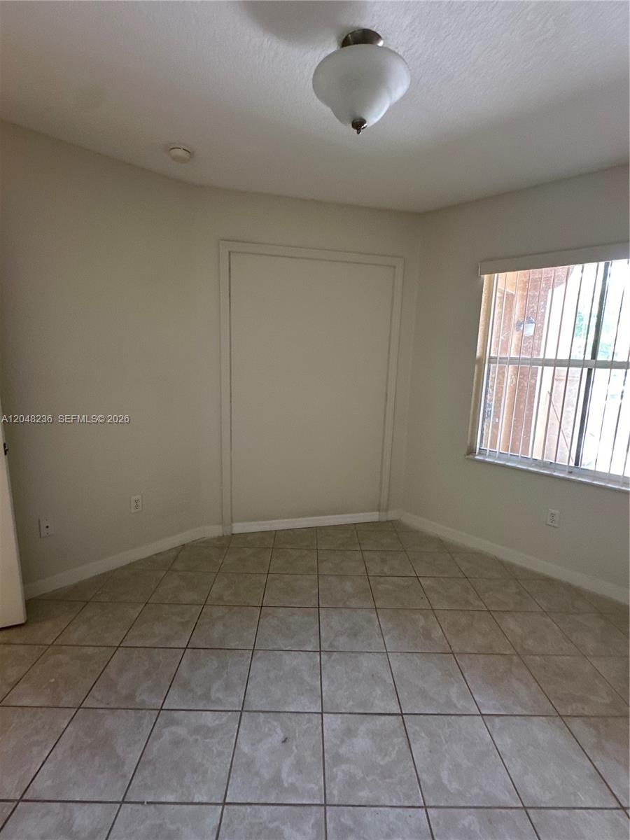 A small room with beige tile flooring, a single window with blinds, and a closet — 4952 Tradewinds Ter # 506, Dania Beach FL 33312, DANIA BEACH, FL