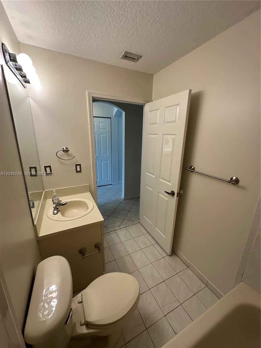 A bathroom features a vanity with a sink, a toilet, and a tiled floor — 4952 Tradewinds Ter # 506, Dania Beach FL 33312, DANIA BEACH, FL
