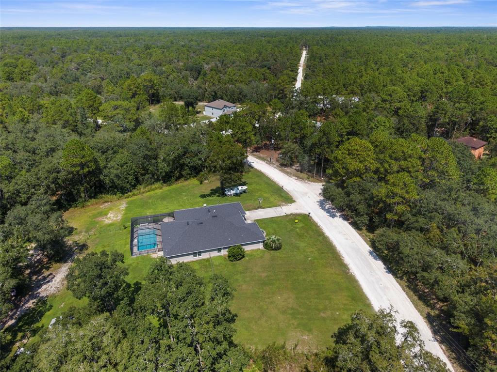 A single-story house with a gray exterior, a two-car garage, and a landscaped front yard — 18209 MERWYN CIR, WEEKI WACHEE, FL