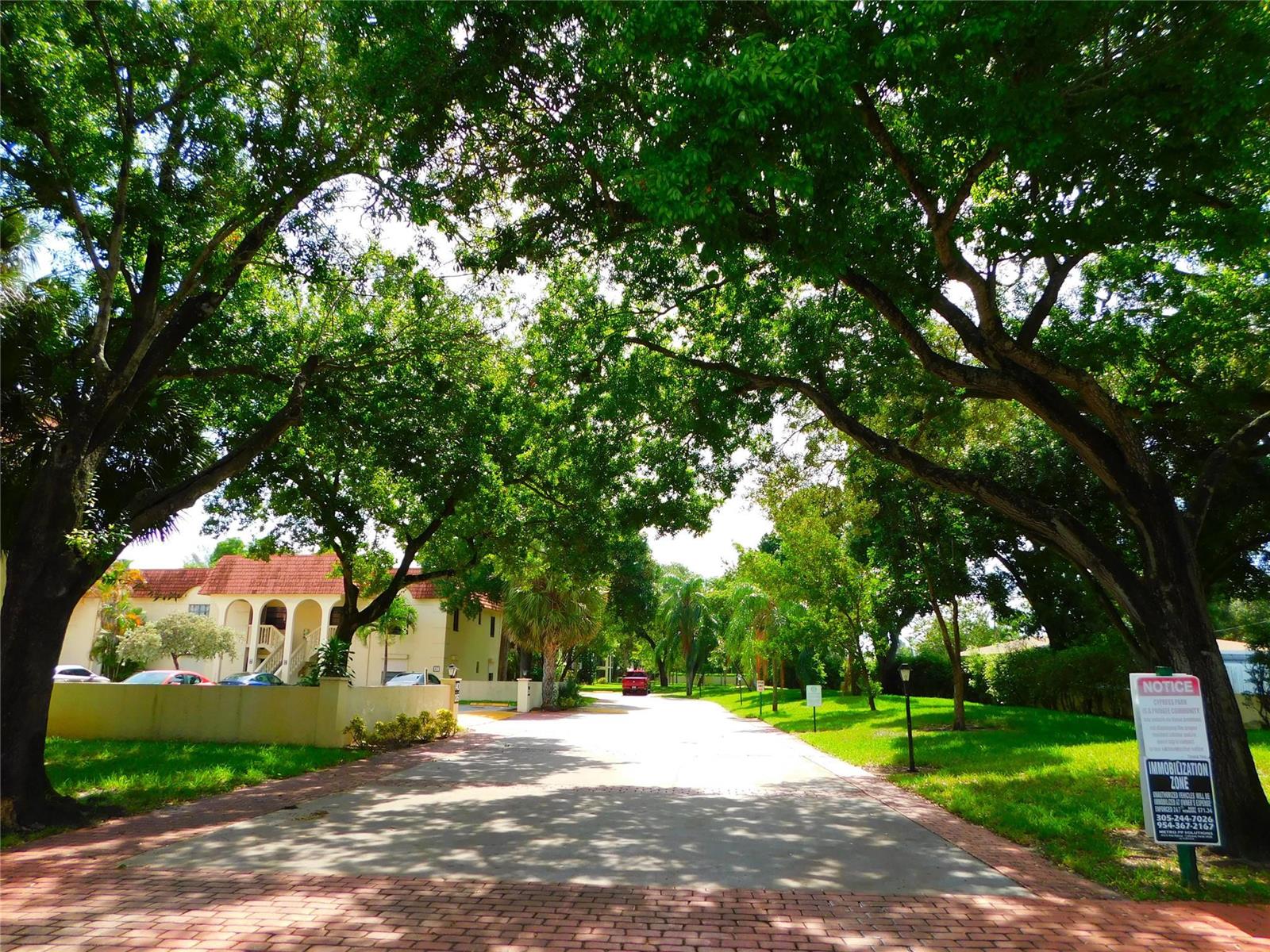 A patio with a storage closet and sliding glass doors leading into a carpeted living room — 128 S Cypress Road # 827, Pompano Beach FL 33060, POMPANO BEACH, FL