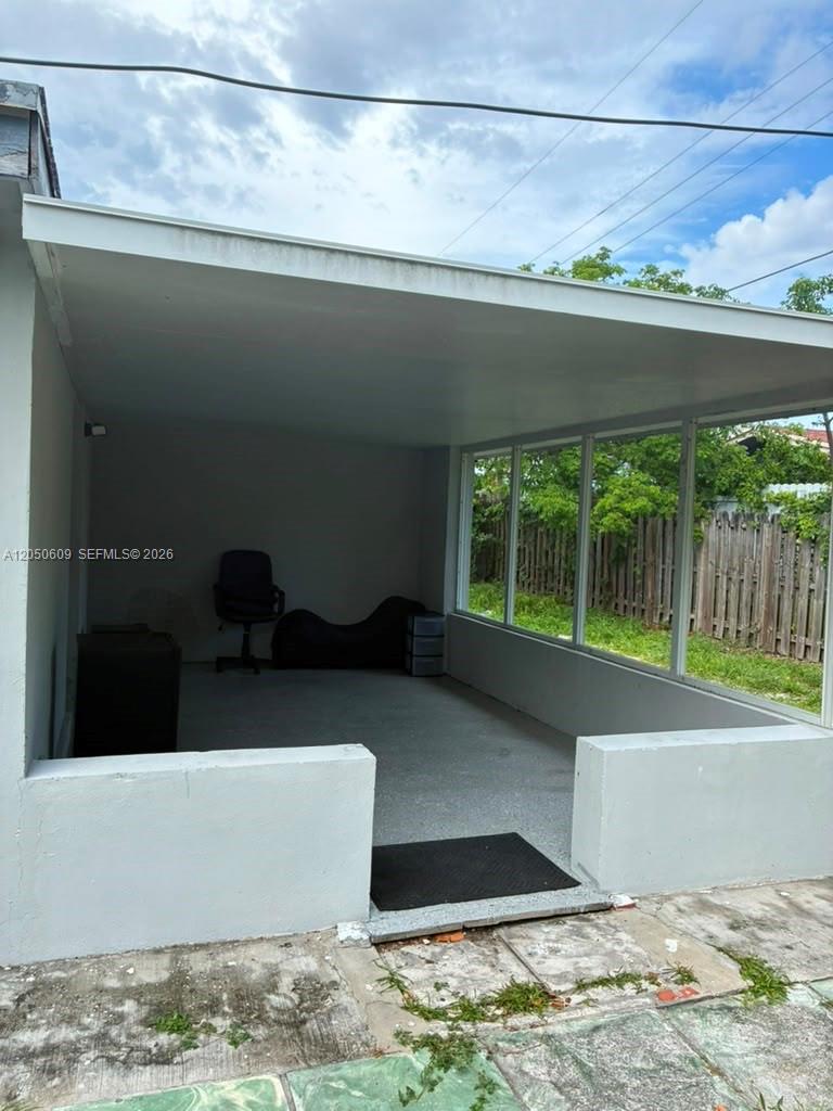 A covered outdoor patio features a concrete floor, white walls, and large screen windows — 3700 NE 13th Ter # 1, Pompano Beach FL 33064, POMPANO BEACH, FL