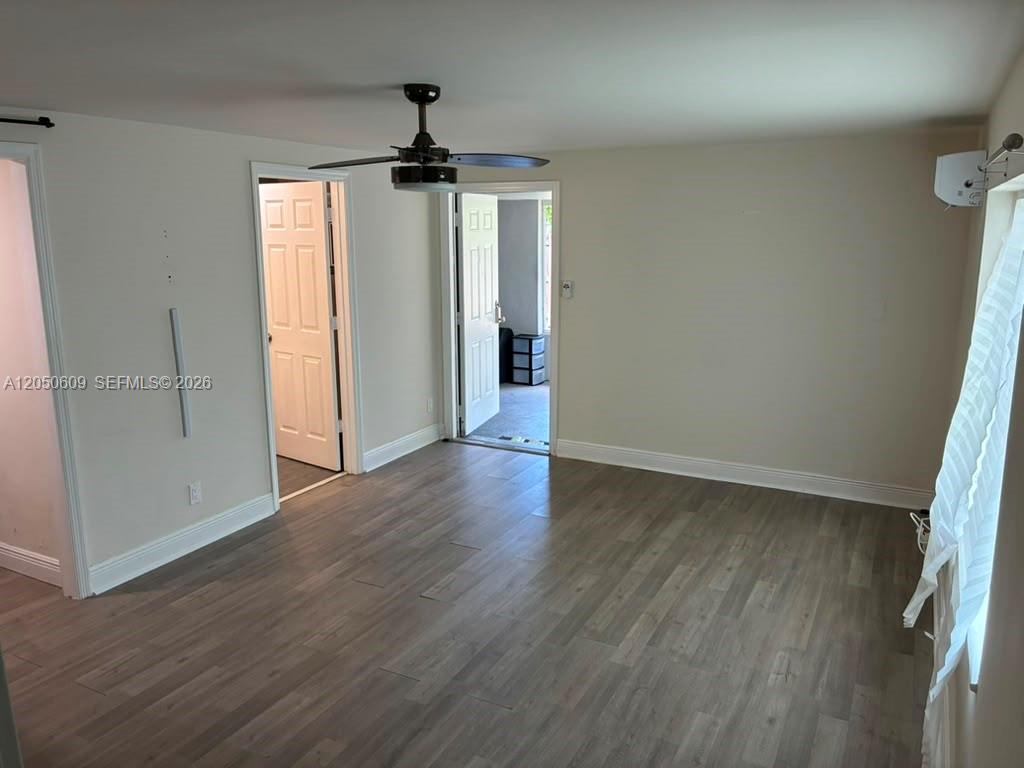 A room with light-colored walls, wood-look flooring, a ceiling fan, and two open doorways — 3700 NE 13th Ter # 1, Pompano Beach FL 33064, POMPANO BEACH, FL