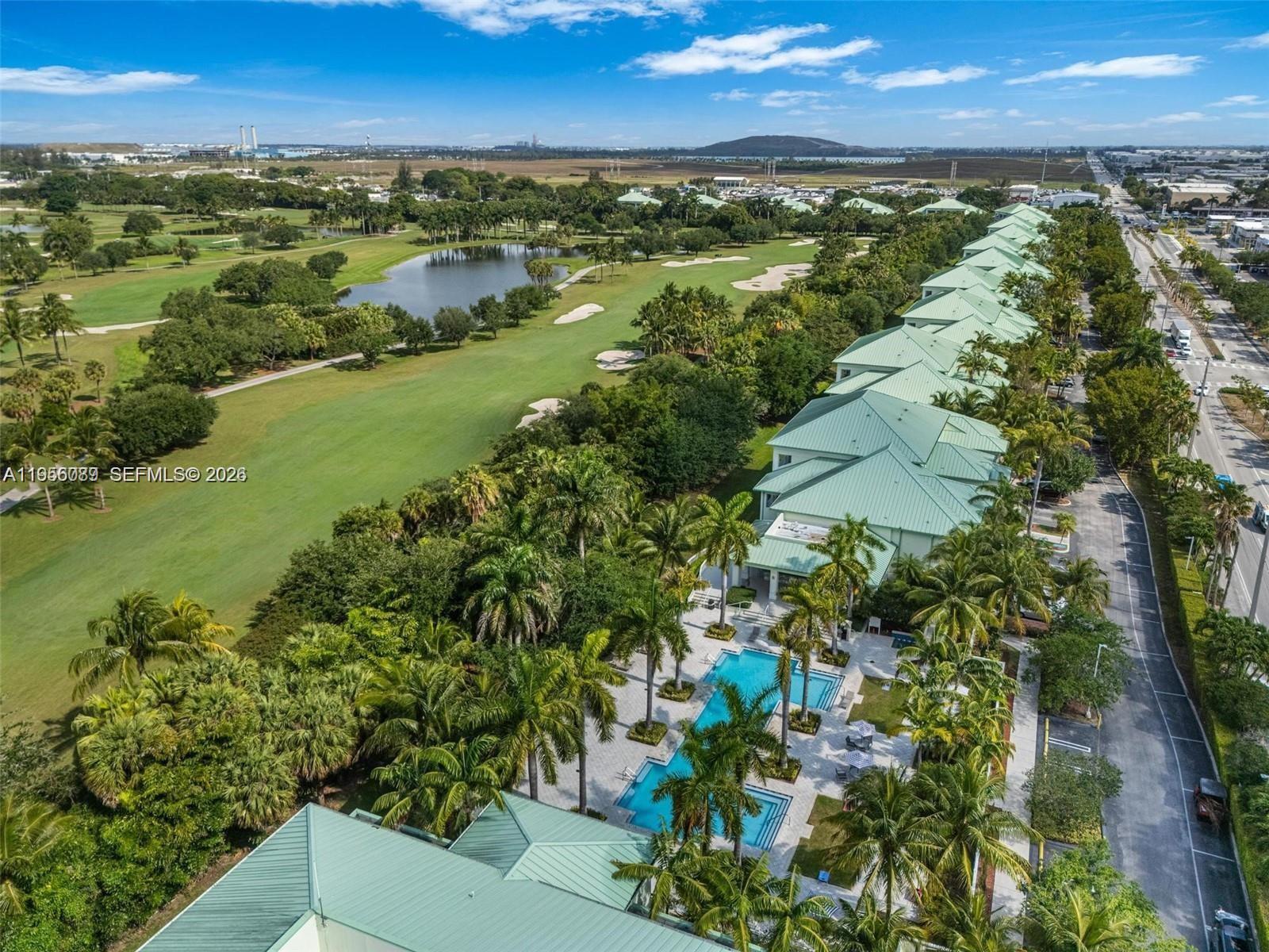 An aerial view shows a multi-unit residential complex with green roofs, a pool, and golf course — 5300 NW 87th Ave # 1209, Doral FL 33178, DORAL, FL