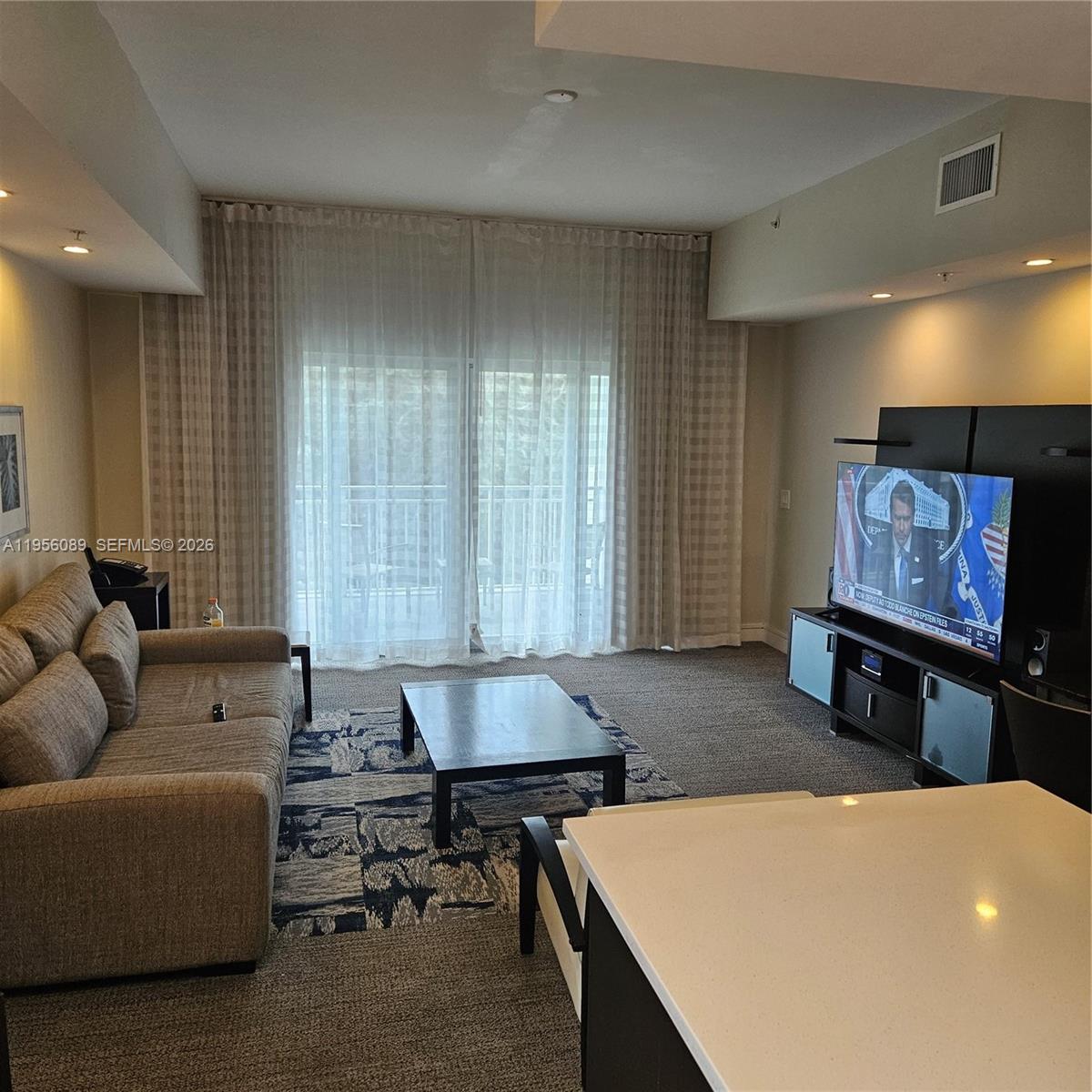 A living room features a sofa, coffee table, television console, and floor-to-ceiling curtains — 5300 NW 87th Ave # 1209, Doral FL 33178, DORAL, FL