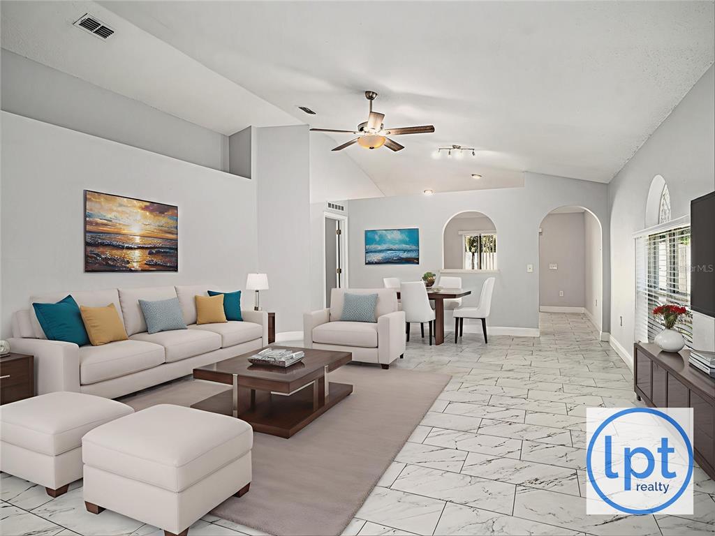 A living room with white tile floors, a vaulted ceiling, and an open dining area — 11433 IVY FLOWER LOOP, RIVERVIEW, FL