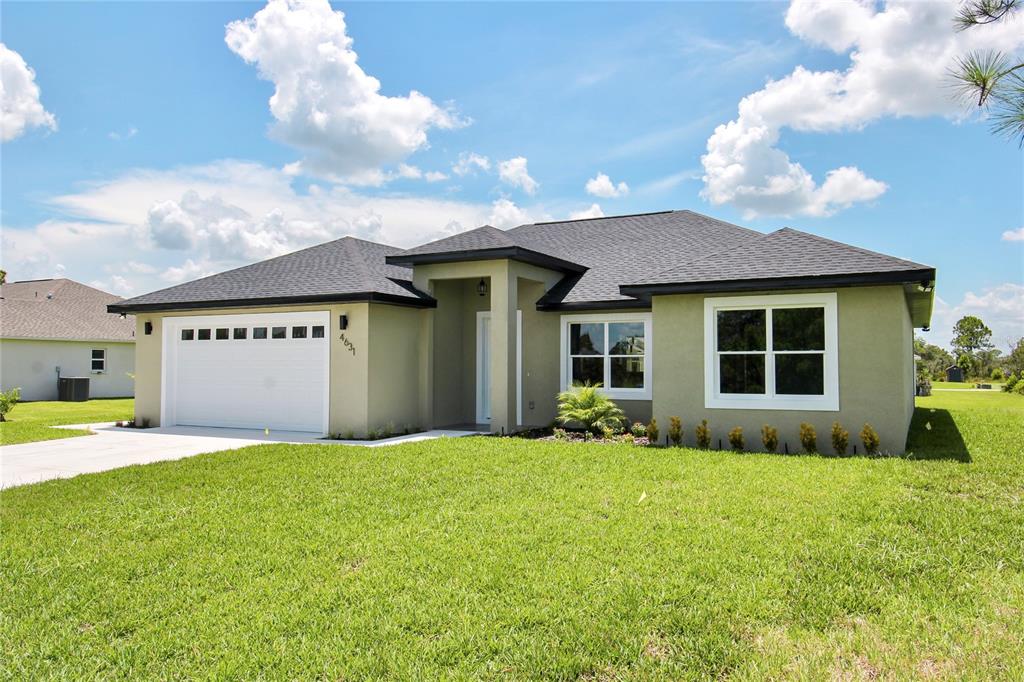 A single-story house with a green stucco exterior, a two-car garage, and a shingled roof — 4631 MIGNON DRIVE, SEBRING, FL