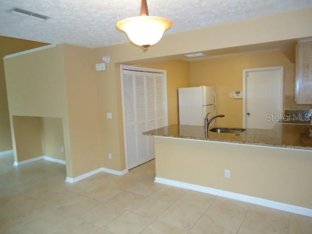 A kitchen with a breakfast bar, white appliances, and light-colored tile flooring — 4012 CIRCLEWOOD COURT, TAMPA, FL