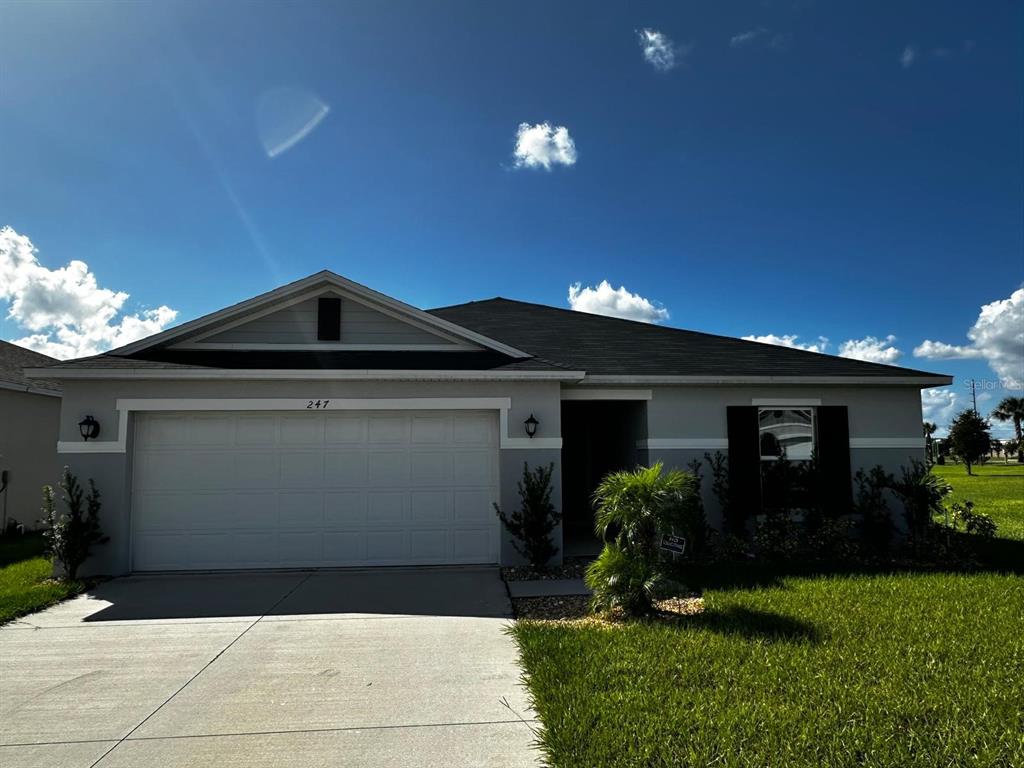 A single-story house with a two-car garage, gray siding, and a dark shingled roof — 247 SUMMERLIN LOOP, HAINES CITY, FL