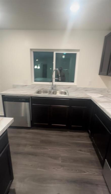 A kitchen features dark cabinets, a stainless steel dishwasher, a double sink, and light countertops — 247 SUMMERLIN LOOP, HAINES CITY, FL