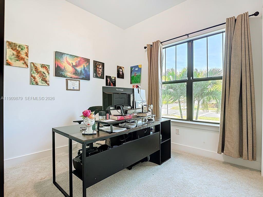 A home office features a black desk, a computer monitor, and wall art near a window — 4250 Annapolis Ave, Ave Maria FL 34142, AVE MARIA, FL