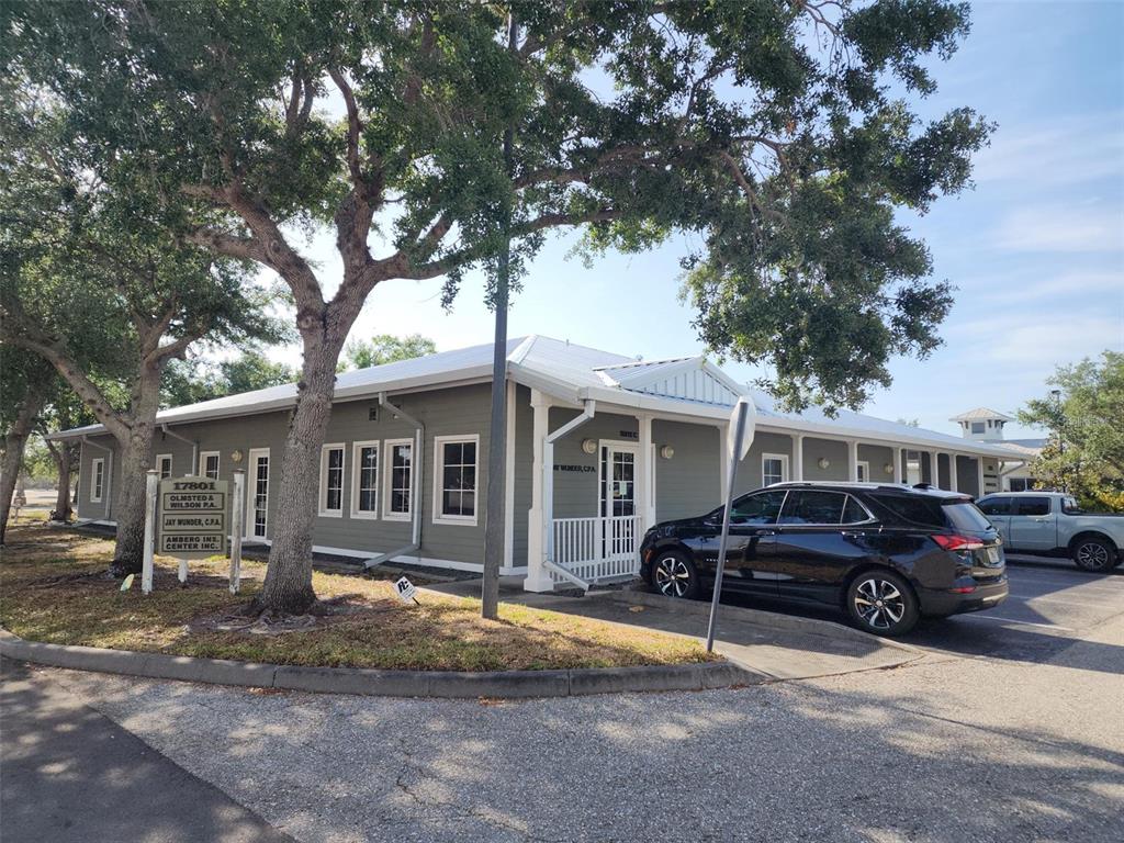 A single-story office building with gray siding and a white roof sits near a parking lot — 17801 MURDOCK CIRCLE UNIT C, PORT CHARLOTTE, FL