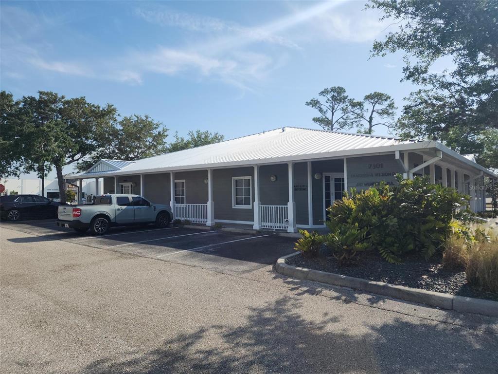 A single-story commercial building with a white metal roof and a parking lot in front — 17801 MURDOCK CIRCLE UNIT C, PORT CHARLOTTE, FL