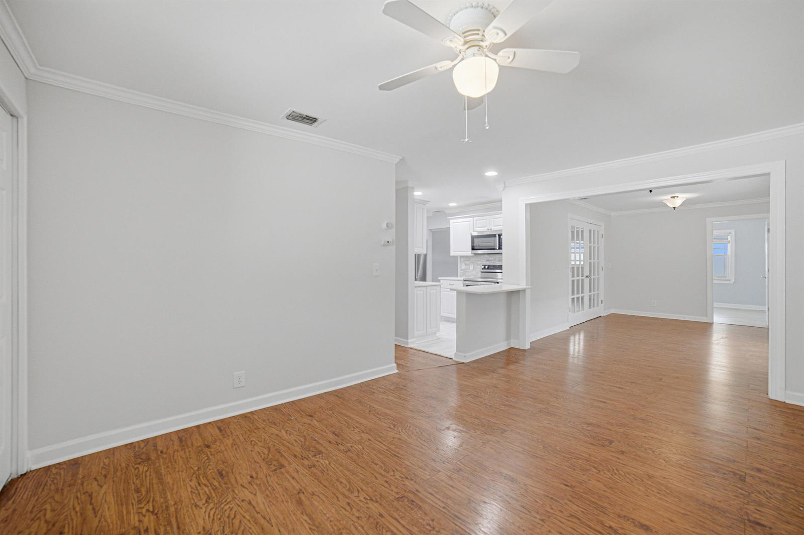 A bright living area with wood flooring, a ceiling fan, and an open kitchen view — 1907 SW 16th Avenue, Boynton Beach FL 33426, BOYNTON BEACH, FL