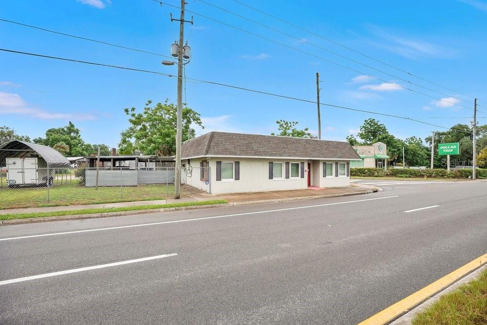 A single-story commercial building with a hip roof sits beside a road and utility pole — 3101 N ORANGE BLOSSOM TRAIL, ZELLWOOD, FL