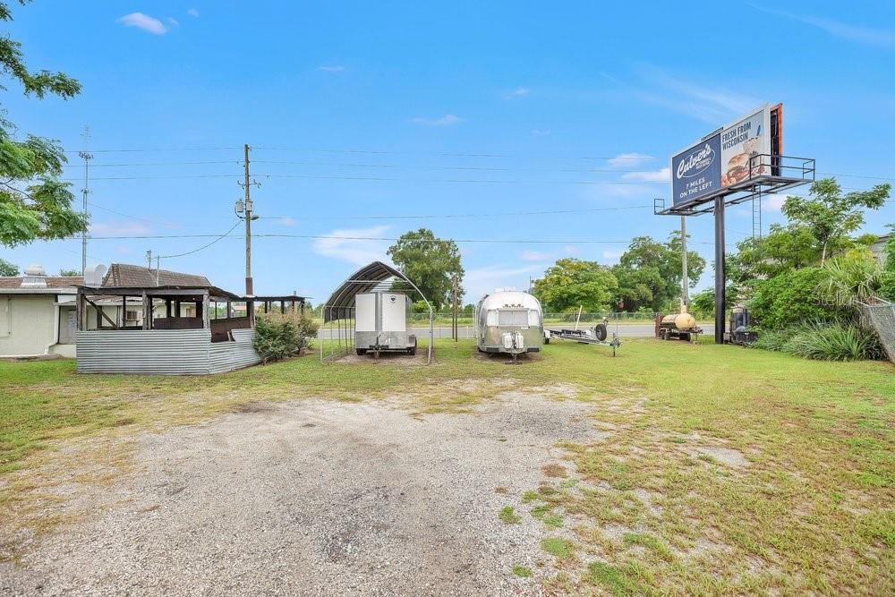 An outdoor lot features a metal shed, two trailers, and a large Culver's billboard — 3101 N ORANGE BLOSSOM TRAIL, ZELLWOOD, FL
