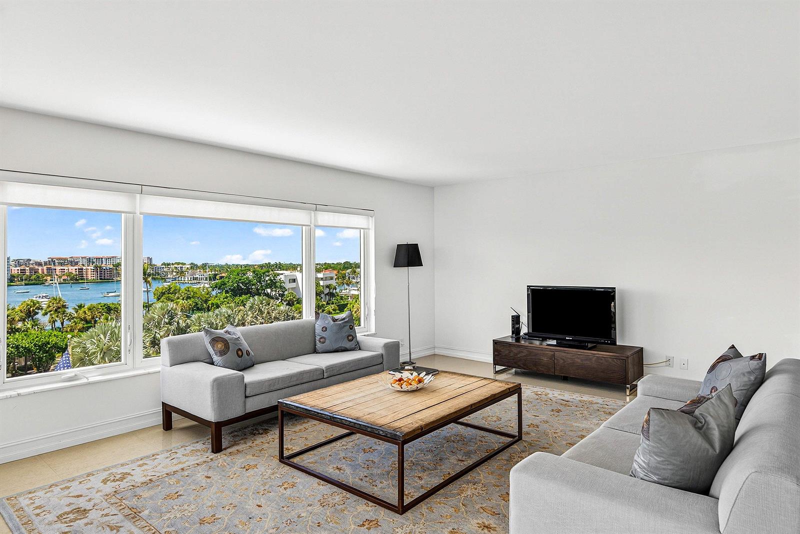 A living room with two gray sofas, a wooden coffee table, and a waterfront view — 600 S Ocean Boulevard # 504, Boca Raton FL 33432, BOCA RATON, FL
