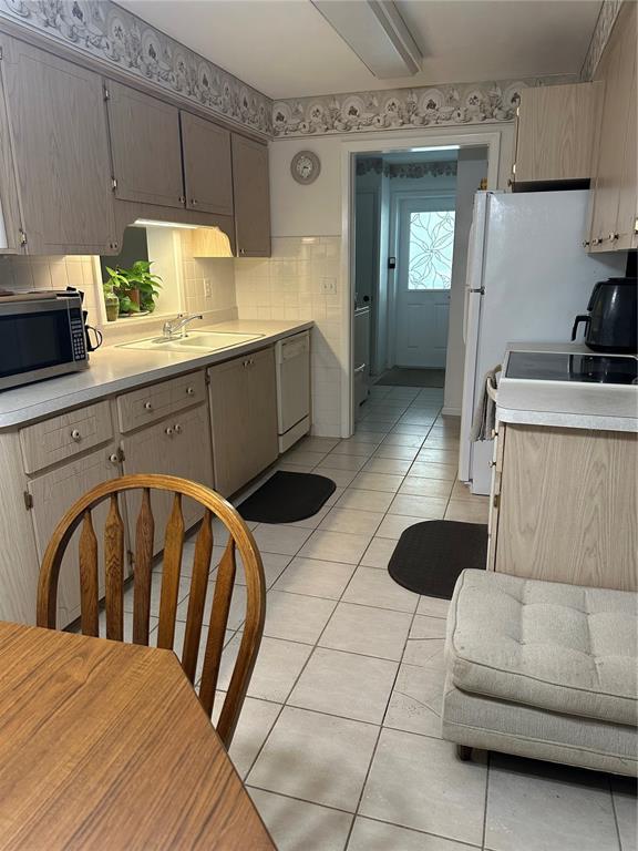 A kitchen features light wood cabinets, white tile countertops, and a tiled floor — 3 S FILLMORE STREET, BEVERLY HILLS, FL