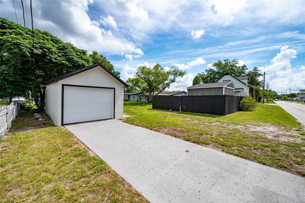 A detached white garage with a concrete driveway sits on a grassy lot — 922 DELAWARE AVENUE, ST CLOUD, FL