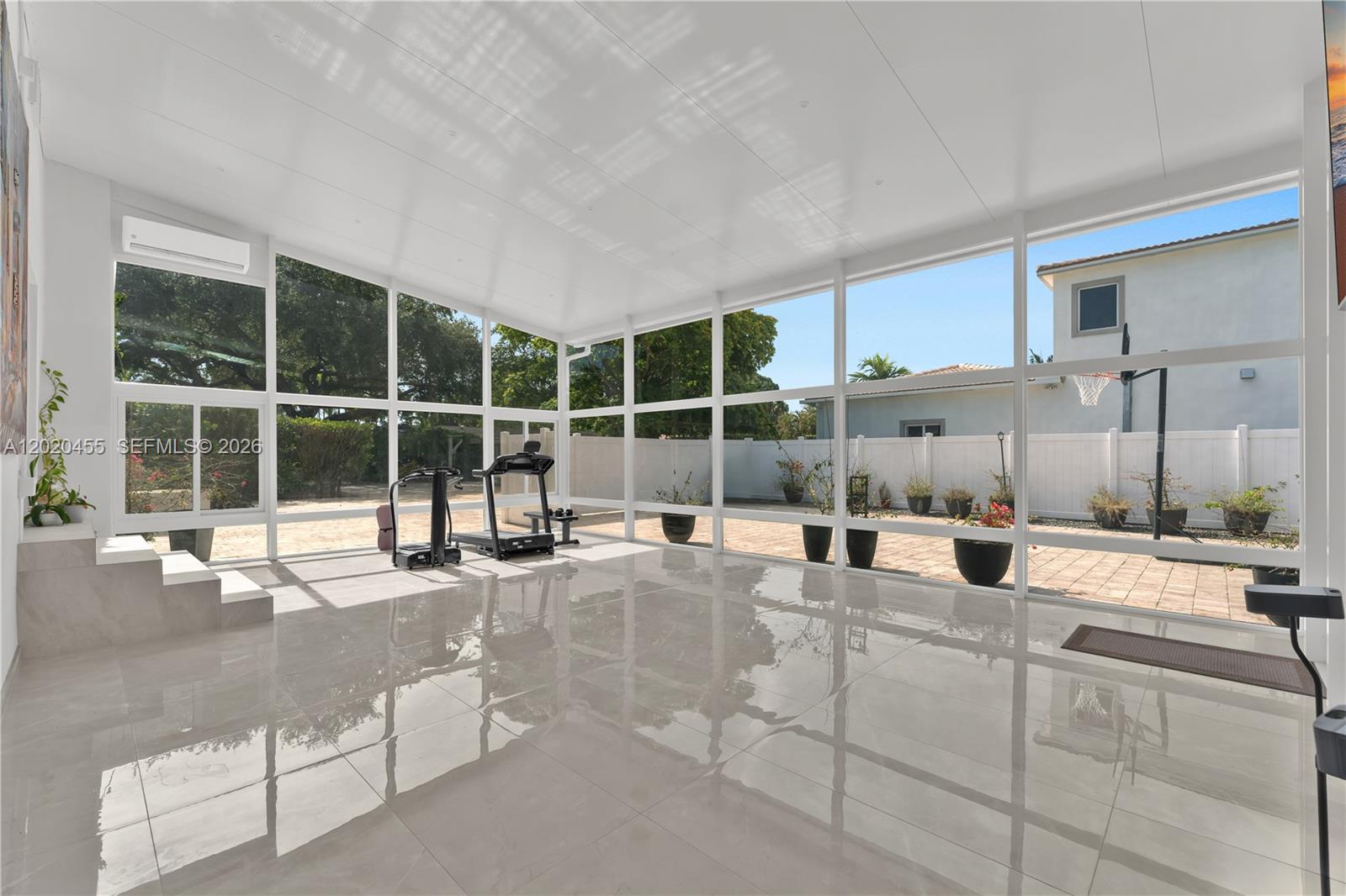 A bright sunroom features large glass windows, white framing, and polished tile flooring — 11144 NE 8th Ct, Biscayne Park FL 33161, BISCAYNE PARK, FL