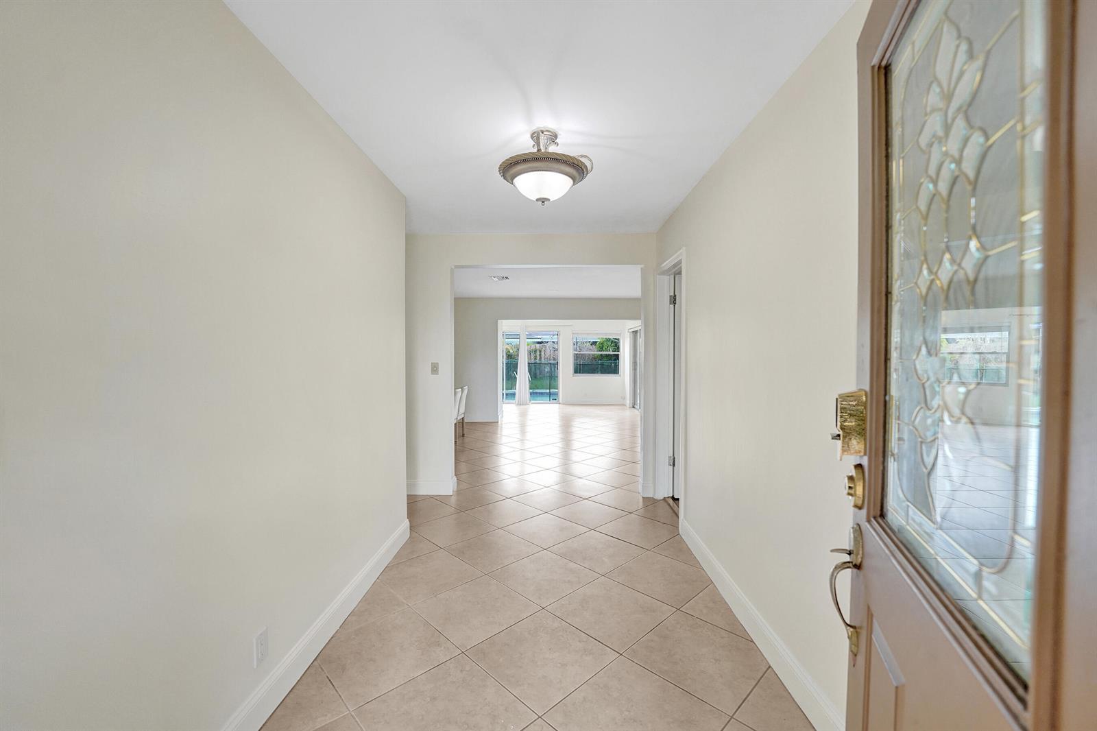 An entryway with beige tile flooring leads into a bright, open-concept living area — 4721 Sarazen Drive, Hollywood FL 33021, HOLLYWOOD, FL