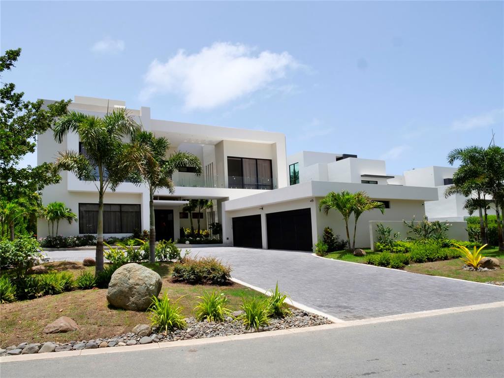 A modern two-story white house features a paved driveway, a two-car garage, and palm trees — 7000 BAHIA BEACH G3 ATLANTIC DRIVE, RIO GRANDE, PR