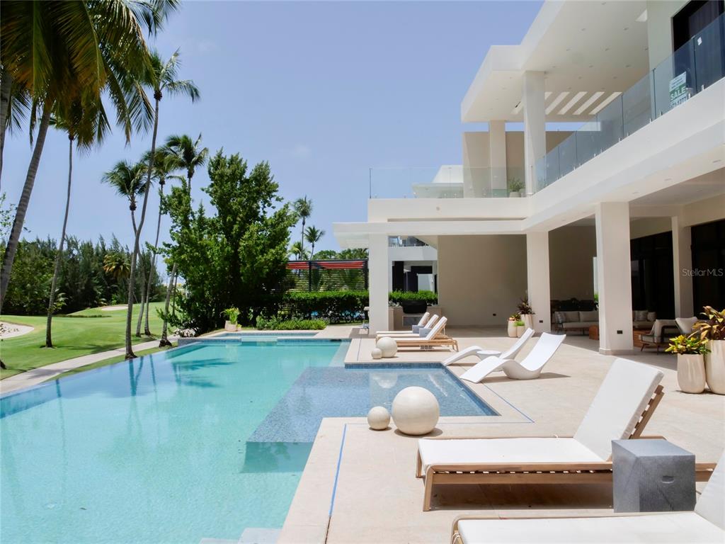 A modern house features a multi-level swimming pool with lounge chairs on a stone patio — 7000 BAHIA BEACH G3 ATLANTIC DRIVE, RIO GRANDE, PR