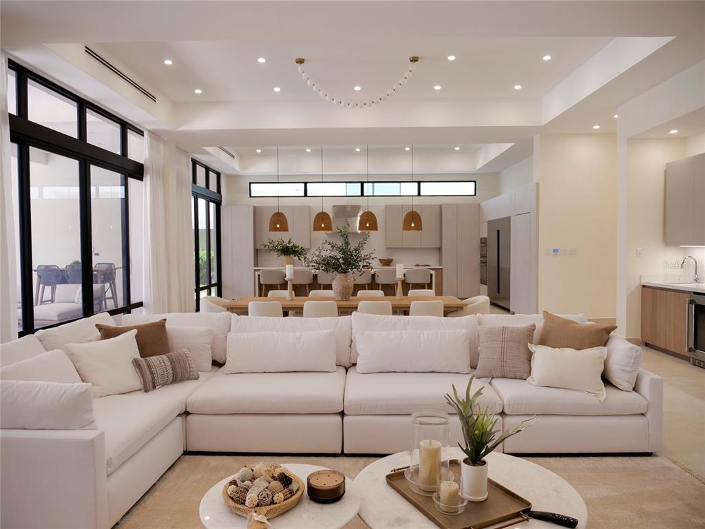 A modern open-concept living room features a large white sectional sofa and a dining area — 7000 BAHIA BEACH G3 ATLANTIC DRIVE, RIO GRANDE, PR