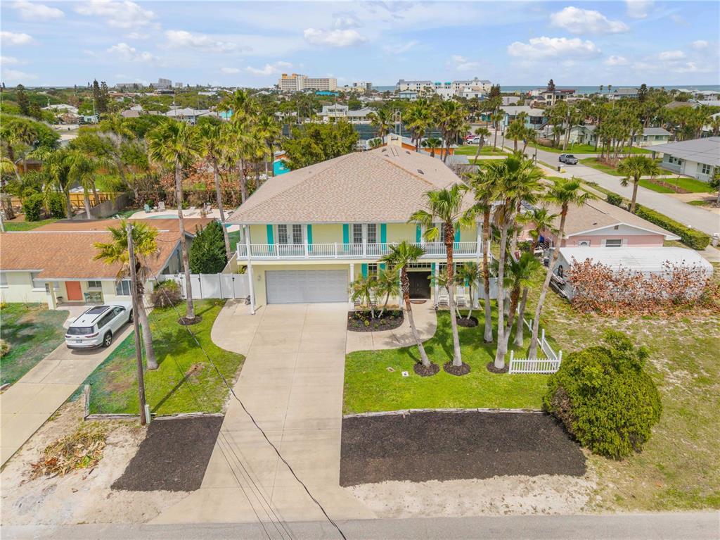 An aerial view of a two-story house with a balcony, garage, and palm trees — 708 OCEAN AVENUE, NEW SMYRNA BEACH, FL