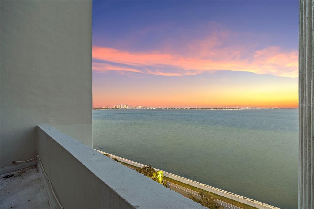 A view of the ocean and distant city skyline from a high-rise balcony at sunset — 4141 BAYSHORE BOULEVARD UNIT 1702, TAMPA, FL