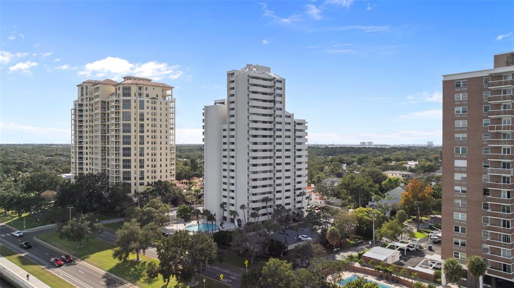 An aerial view shows three high-rise apartment buildings surrounded by trees and parking lots — 4141 BAYSHORE BOULEVARD UNIT 1702, TAMPA, FL