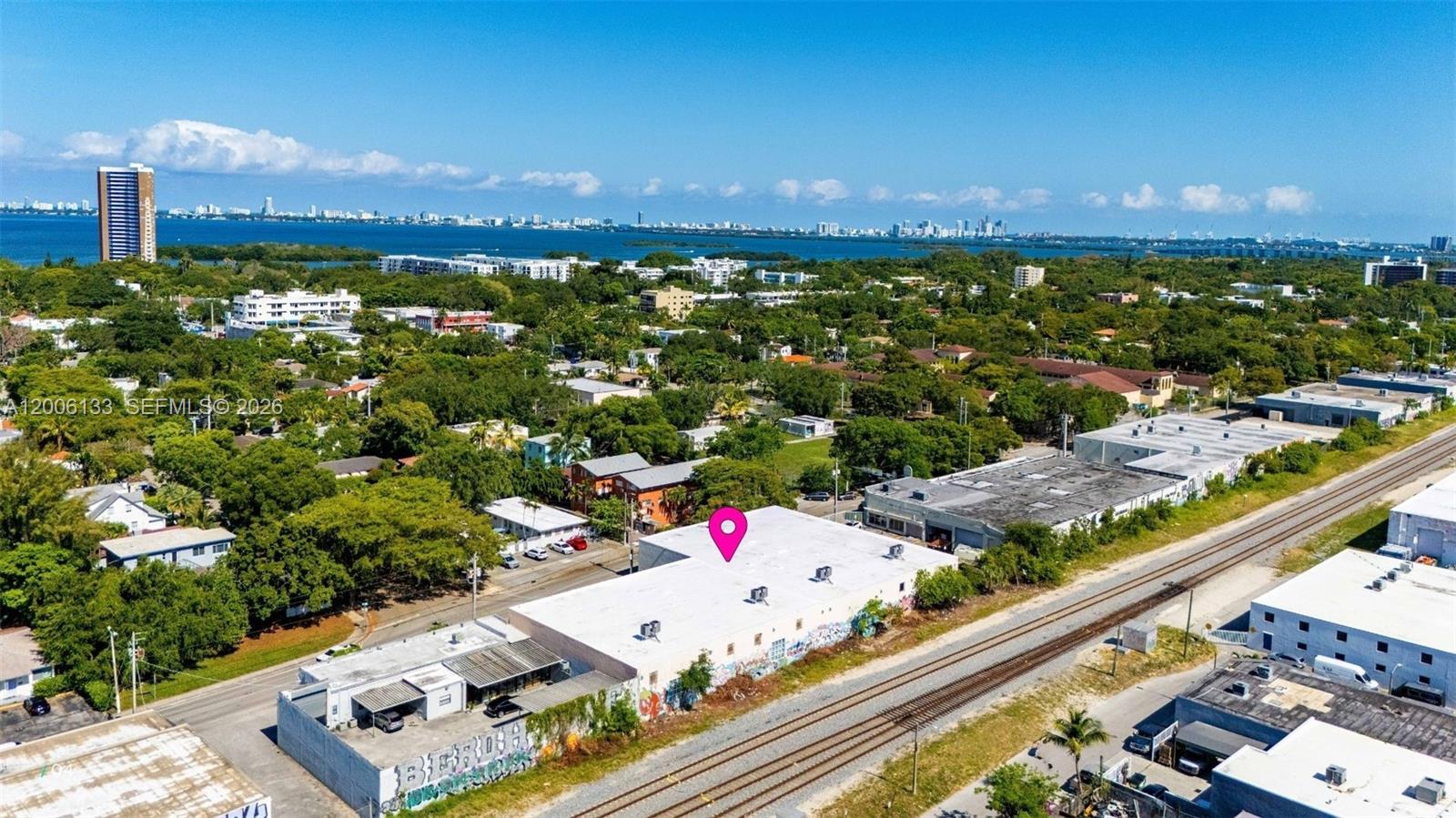 An aerial view shows a flat-roofed industrial building situated next to railroad tracks — 6800 NE 4th Ct, Miami FL 33138, MIAMI, FL