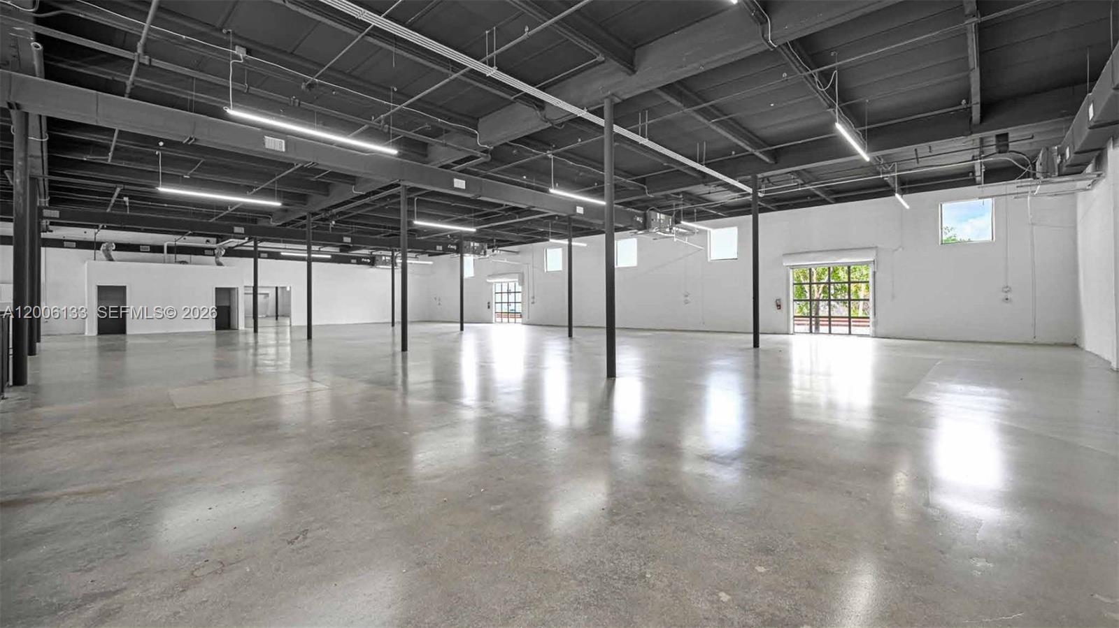 A large, open-plan industrial warehouse space features polished concrete floors and exposed ceiling beams — 6800 NE 4th Ct, Miami FL 33138, MIAMI, FL