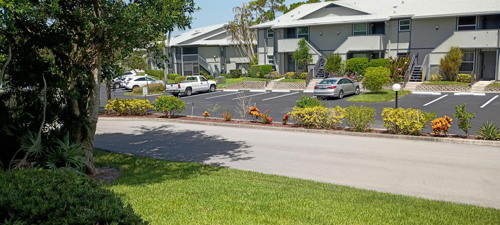 A parking lot sits in front of two-story apartment buildings with light gray siding — 8387 SE Croft Circle # Q3, Hobe Sound FL 33455, HOBE SOUND, FL